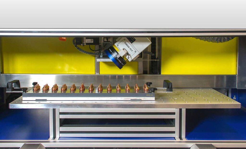 A fiber laser machine with a yellow background.