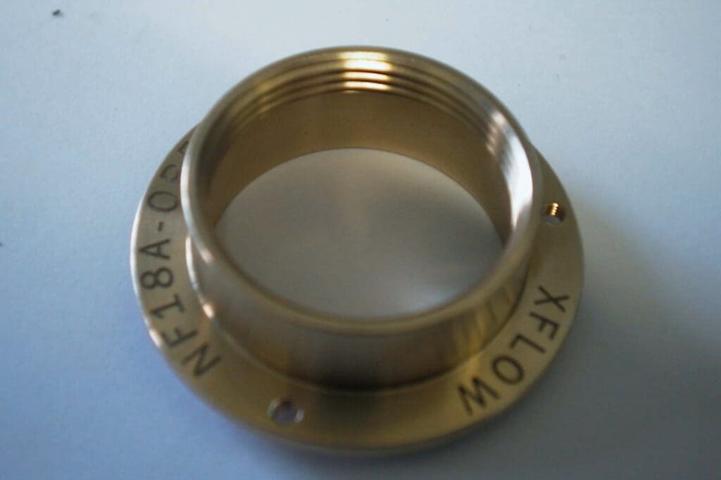A brass lens with the word " theta " on it.