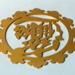 A gold colored sign with chinese characters on it.
