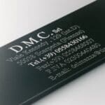 A black business card with white lettering and numbers.