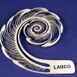 A silver spiral shaped ornament with the name laibo on it.