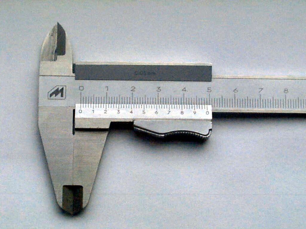 A metal ruler and measuring tape on top of a table.