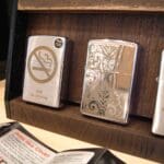 A wooden display case with three different types of lighters.